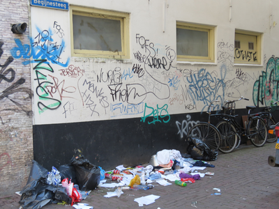 829375 Gezicht in de Begijnesteeg te Utrecht vanuit de Breedstraat, met veel rotzooi en graffiti.